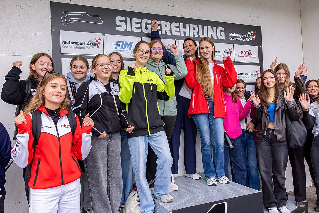 Discover Motorsport – Young Women's Edition 2026 in Oschersleben Gruppenfoto der Teilnehmerinnen auf dem Siegerpodest in der Motorsport Arena Oschersleben.