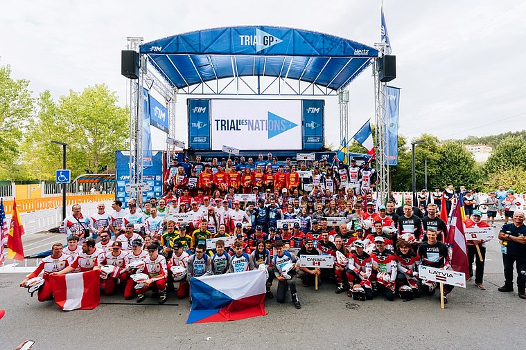 Gruppenfoto der internationalen Teilnehmer des Trial der Nationen vor der Trial-GP-Bühne.