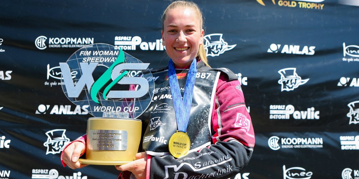 Hannah Grunwald gewinnt FIM Women's Speedway World Cup 2026 Hannah Grunwald mit Siegerpokal und Goldmedaille vor Sponsorenwand nach ihrem Erfolg beim FIM Women's Speedway World Cup in Kroatien.