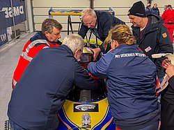 DMSB Medical Days 2026 DMSB Medical Days 2026: Gruppe um blaues Formel-Chassis in Garage bei Rettungsdemo einer Person aus dem Fahrzeug.