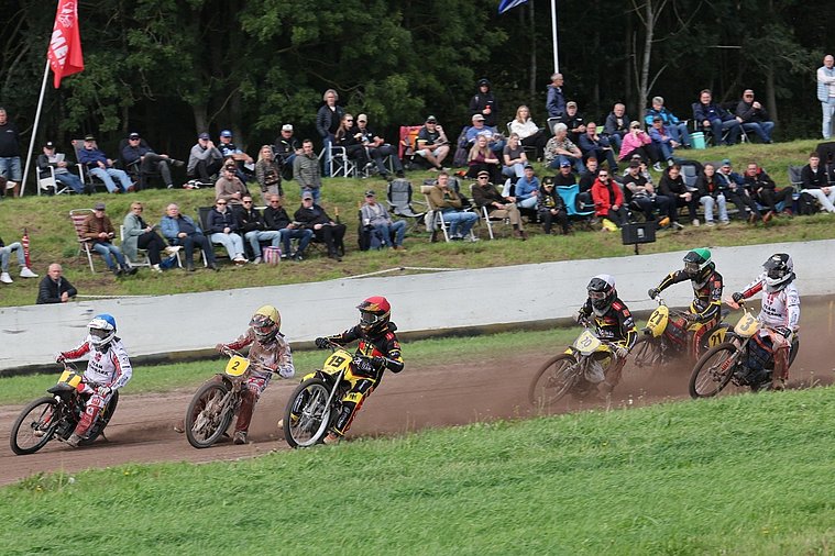 Deutsche Nationalmannschaft, Langbahn-Team-WM 2026, Roden Fünf Langbahnfahrer mit den Startnummern 1, 2, 19, 20, 21 und 3 fahren auf einer Sandbahn durch eine Kurve, während Zuschauer die Rennen am Streckenrand verfolgen.