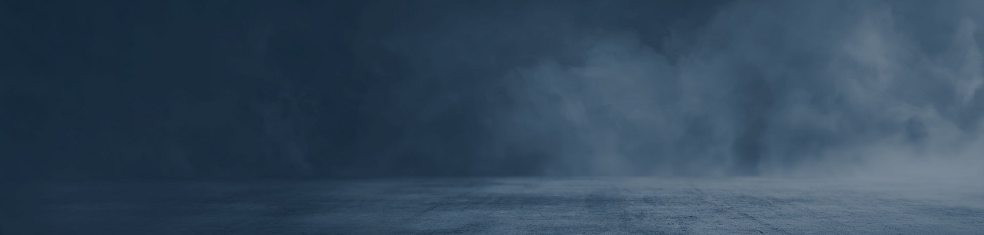 Ein dunkler, leerer Raum mit Betonboden und blauen Nebelschwaden im Hintergrund.